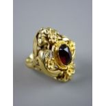 A LARGE OVAL FOURTEEN CARAT GOLD FLORAL DRESS RING with centre oval garnet set, possibly into an