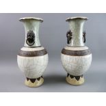 A PAIR OF CHINESE CRACKLE GLAZE CELADON TYPE VASES, the folded rim over a green neck with lion