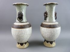 A PAIR OF CHINESE CRACKLE GLAZE CELADON TYPE VASES, the folded rim over a green neck with lion