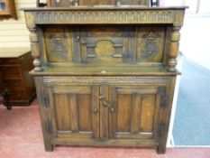 AN EARLY 20th CENTURY RUSTIC POLISHED ONE PIECE COURT CUPBOARD, the upper part having a centre