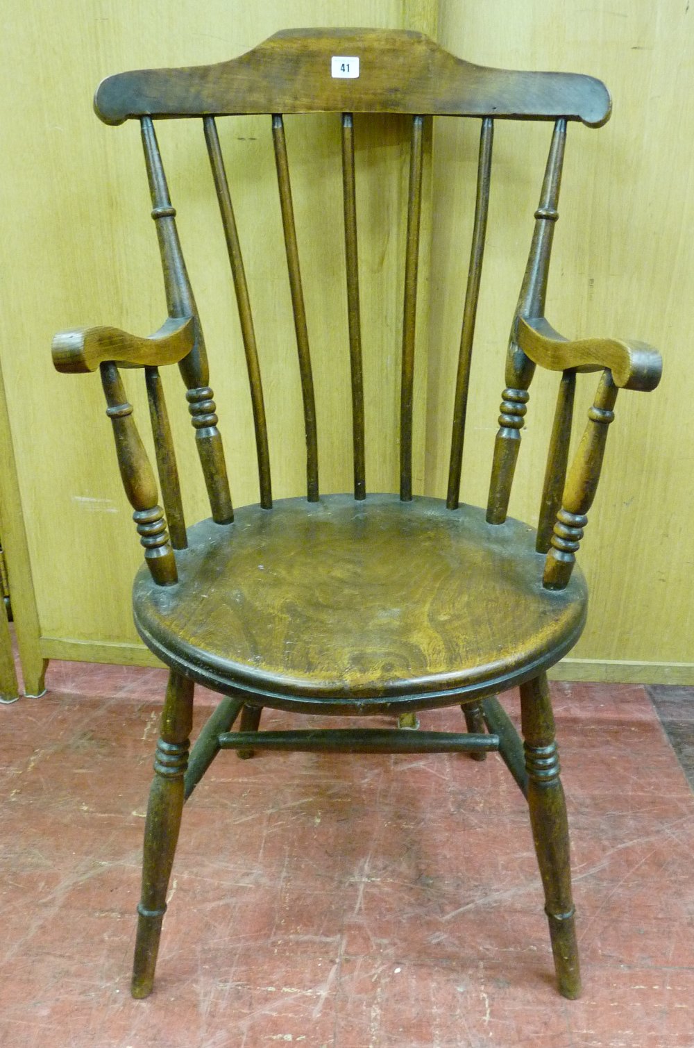 A POLISHED CIRCULAR SEATED SPINDLEBACKED ELBOW CHAIR