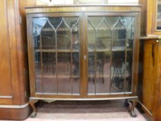 AN EARLY 20th CENTURY MAHOGANY TWO DOOR CHINA CABINET, each glass door with shaped panes on ball and