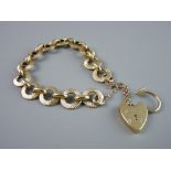 A NINE CARAT GOLD BRACELET of circular discs with oval links and with padlock and safety chain, 22.9