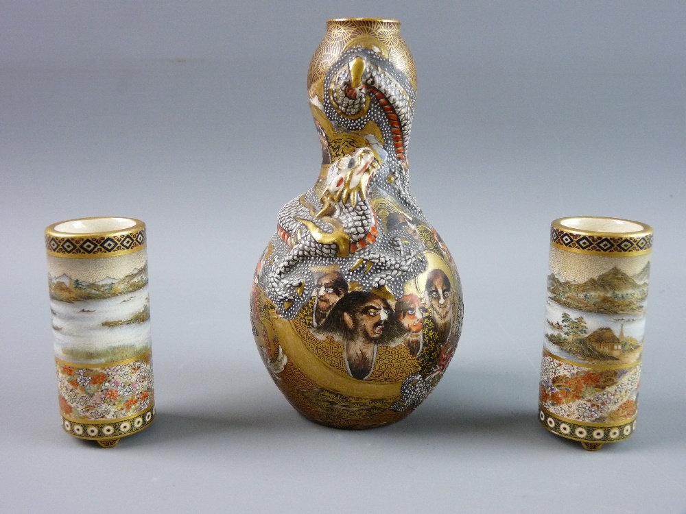 A FINELY DECORATED PAIR OF MINIATURE SATSUMA CYLINDRICAL VASES on three short supports, each with an