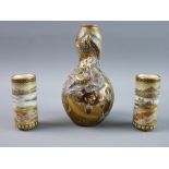 A FINELY DECORATED PAIR OF MINIATURE SATSUMA CYLINDRICAL VASES on three short supports, each with an