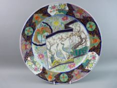 AN EXCELLENT ORIENTAL PORCELAIN WALL CHARGER, 39.5 cms diameter dish shaped with a panelled border