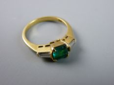 AN EIGHTEEN CARAT GOLD DRESS RING with centre square cut emerald and flanking baguette diamonds,