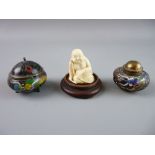 A JAPANESE IVORY NETSUKE of a seated figure and two miniature cloisonné containers, one an inkpot