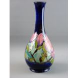 A MOORCROFT 'MAGNOLIA' BOTTLE VASE, 32 cms high, decorated on a cobalt blue ground, original