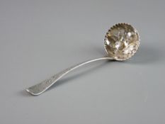 AN ORNATE SILVER SUGAR SIFTER, the bowl with raised fruit and leaf decoration and the handle with