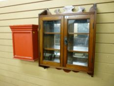 AN EDWARDIAN MAHOGANY TWO DOOR GLAZED HANGING MEDICINE CABINET with a shaped top rail, two