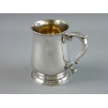 A GEORGE II SILVER TANKARD of plain waisted form with scroll handle and circular foot, 12 cms