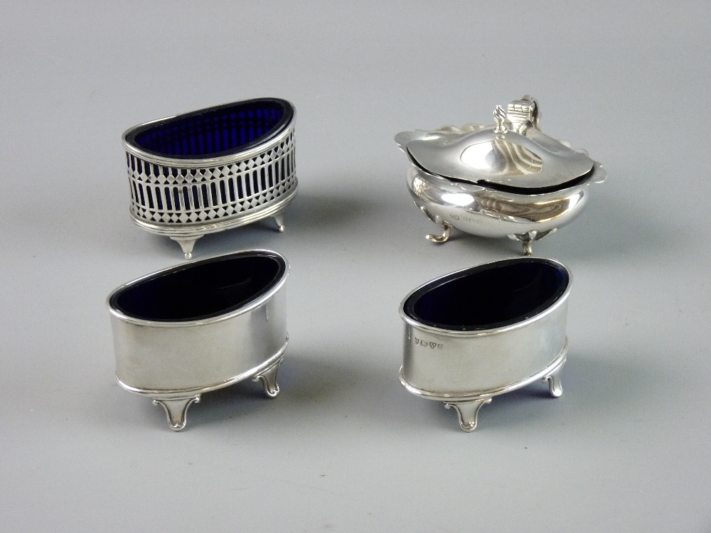 A GROUP OF SILVER SALTS to include a lidded example on four feet, a pierced oval on four feet,