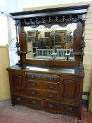 AN EDWARDIAN CARVED WALNUT MIRROR BACK SIDEBOARD, the inverted cornice over a pierced ribbon swag