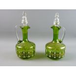 A PAIR OF GREEN GLASS DECANTERS WITH STOPPERS, the bodies with gilt and enamel decoration, 28 cms