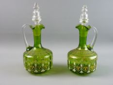 A PAIR OF GREEN GLASS DECANTERS WITH STOPPERS, the bodies with gilt and enamel decoration, 28 cms