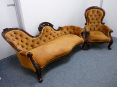 A VICTORIAN CARVED MAHOGANY CAMEL BACK COUCH & MATCHING ARMCHAIR, the open carved back with floral