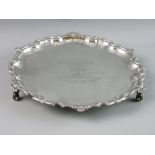 A CIRCULAR SILVER SALVER with bead and shell wavy border on three scroll supports by J B