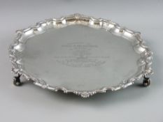 A CIRCULAR SILVER SALVER with bead and shell wavy border on three scroll supports by J B