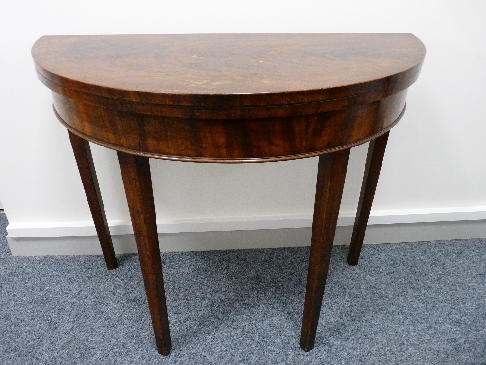 A GEORGIAN MAHOGANY CIRCULAR FOLDOVER CARD TABLE on square tapering supports, 74 cms high, 89 cms