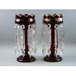 A PAIR OF VICTORIAN RUBY GLASS LUSTRES having crown patterned tops with gilded decoration and