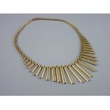A NINE CARAT GOLD NECKLET in the Egyptian style having plain graduated oblong drops with three bar