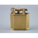A NINE CARAT GOLD ENGINE TURNED DUNHILL CIGARETTE LIGHTER of oblong form with angled corners, 32