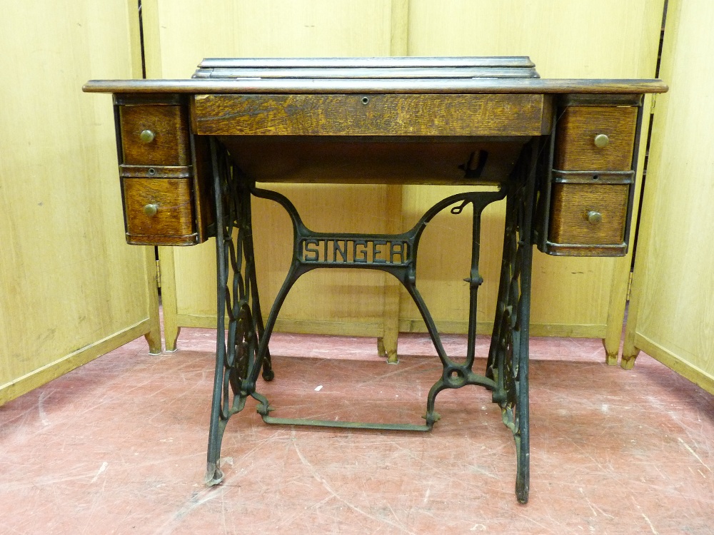 A POLISHED ENCASED SINGER TREADLE SEWING MACHINE with two small drawers at each end