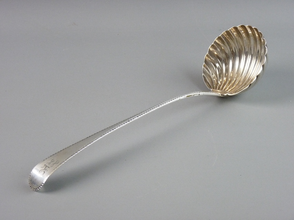 A FINE SILVER SOUP LADLE, the 9 cms bowl of shell form and the tapered handle having feather edgin