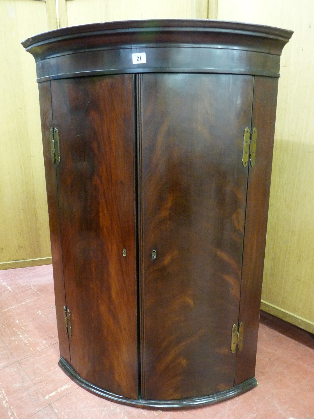 A GEORGIAN MAHOGANY HANGING WALL CUPBOARD with twin bow fronted doors, brass 'H' hinges and green
