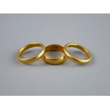 A TWENTY TWO CARAT GOLD WIDE WEDDING BAND and two twenty two carat gold narrow wedding bands, 14.8