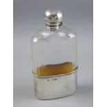 A HEAVY GLASS HIP FLASK with oval gilt silver holder, 2.6 troy ozs, London 1897 and with mushroom