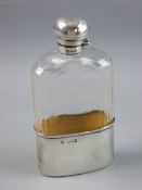 A HEAVY GLASS HIP FLASK with oval gilt silver holder, 2.6 troy ozs, London 1897 and with mushroom