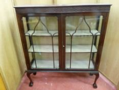 AN EDWARDIAN MAHOGANY TWO DOOR CHINA CABINET with blind fret frieze and beaded panelled doors on