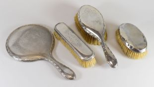 THREE MATCHING SILVER DRESSING TABLE ITEMS comprising two brushes and mirror with engraved floral