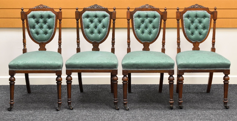A SET OF FOUR DRAWING ROOM CHAIRS having shield backs with buttoned upholstery and carved rails