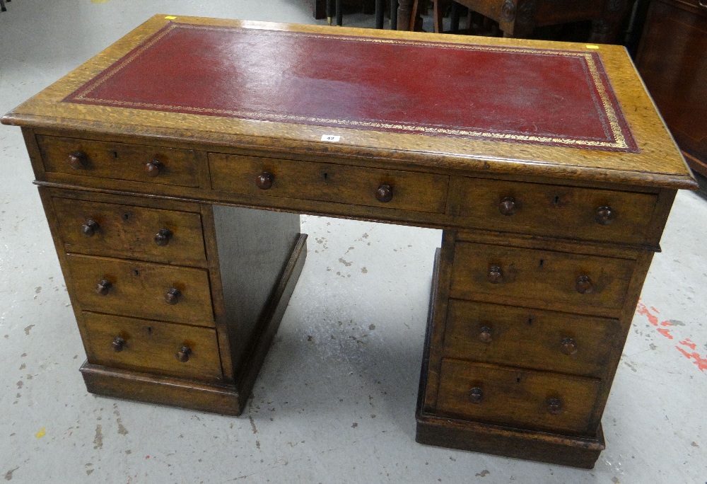 AN ANTIQUE OAK PEDESTAL WRITING DESK having twin pedestals with a bank of three drawers to each