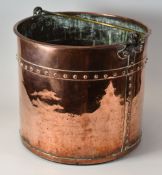 AN ANTIQUE RIVETED COPPER LOG-BIN with brass swing-handle, 31cms high