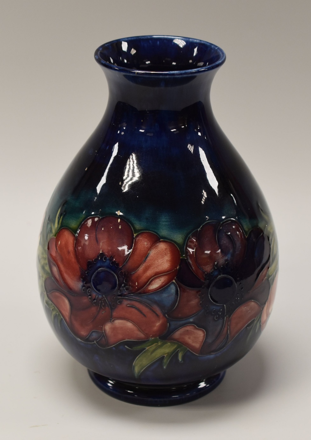 A MOORCROFT ANEMONE BALUSTER VASE the tube-lined pink and red flowers to a blue and green reserve,