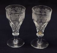 A PAIR OF EARLY NINETEENTH CENTURY WINE GLASSES having vine etched and faceted bowls above knopped