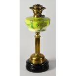 AN ANTIQUE OIL LAMP having a painted green glass reservoir supported by a reeded brass column with