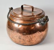 AN ANTIQUE COPPER COOKING POT of bulbous form complete with lid having an iron swing handle, 25cms
