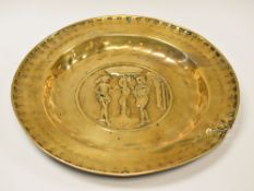 A 17TH CENTURY NUREMBURG BRASS ALMS DISH relief decorated with a central depiction of Adam and Eve