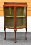 A TWO-DOOR INLAID MAHOGANY BOW FRONT CHINA CABINET on cabriole corner supports and with railback