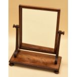 A NINETEENTH CENTURY MAHOGANY TOILET MIRROR on bun feet with bead rim and fluted supports, 56cms