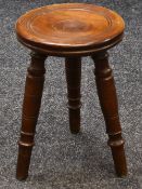 A NINETEENTH CENTURY CIRCULAR TOPPED TRIPOD MILKING STOOL