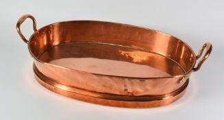 AN ANTIQUE COPPER POACHING PAN of oval footed form and with upturned loop handles, 53cms wide