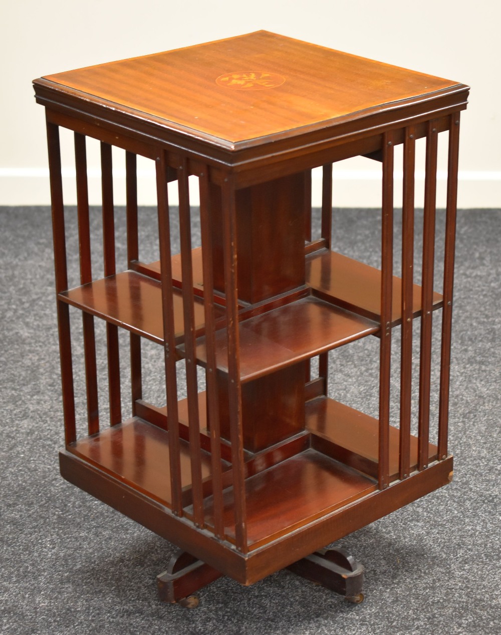 AN INLAID MAHOGANY REVOLVING BOOKCASE of cubic form and having a marquetry cartouche