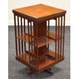 AN INLAID MAHOGANY REVOLVING BOOKCASE of cubic form and having a marquetry cartouche