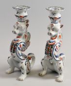 PAIR OF QUIMPER CANDLE-HOLDERS typically painted in the Breton style in the form of two seated